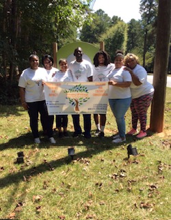 Vitality Village volunteers holding the organization banner outdoors