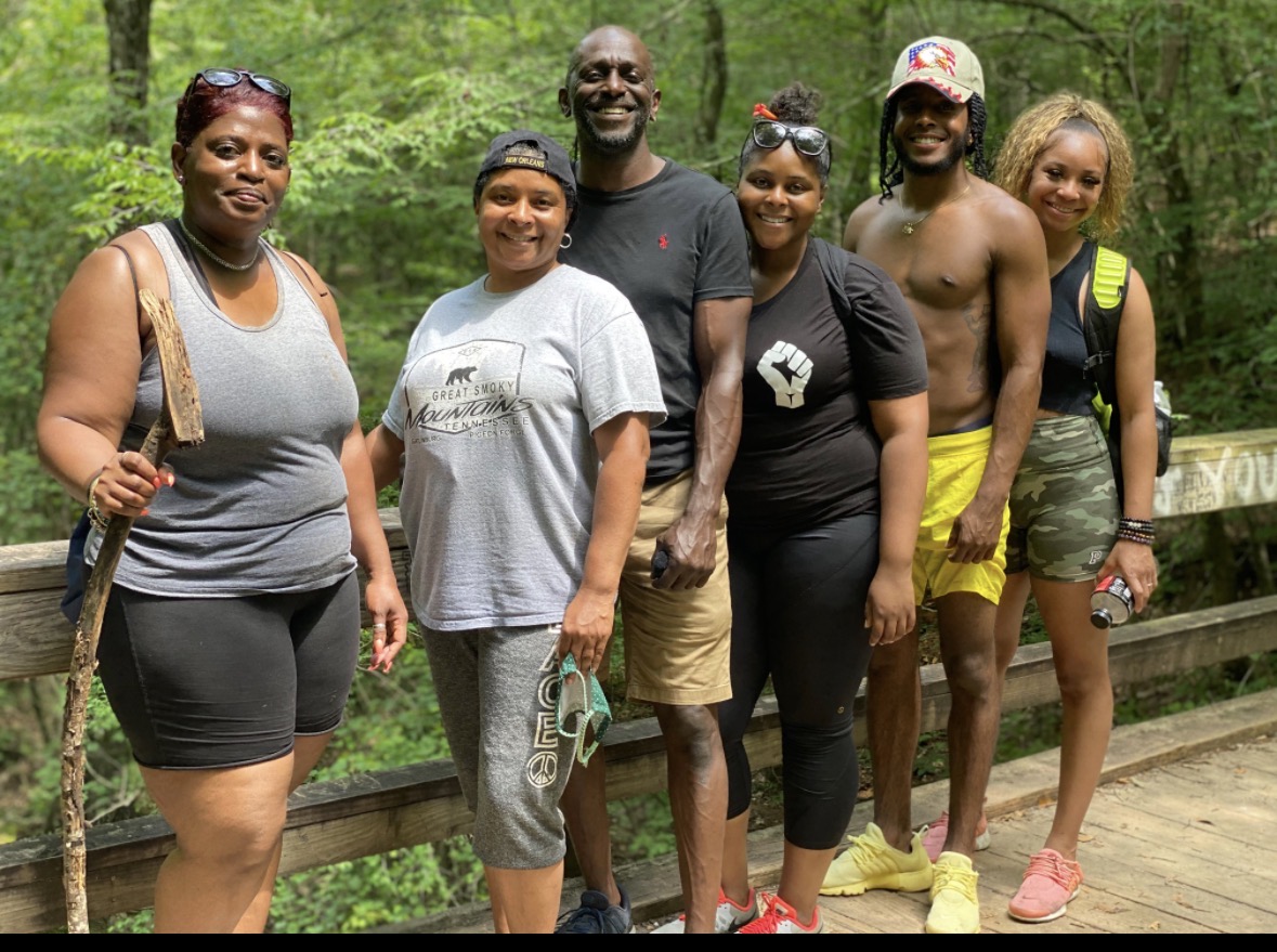 Vitality Village hikers gathered on a wooden bridge in the woods