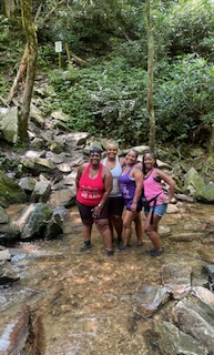Group hike through a creek on a Wilderness Wellness outing