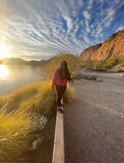 Founder Shundrika Williams walking along the water at sunset