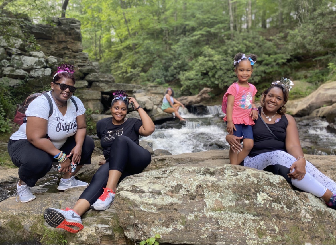 Village members resting by a waterfall during an outdoor wellness retreat