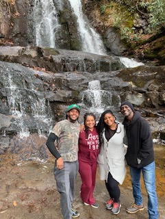 Family and friends posing in front of a waterfall on a guided hike